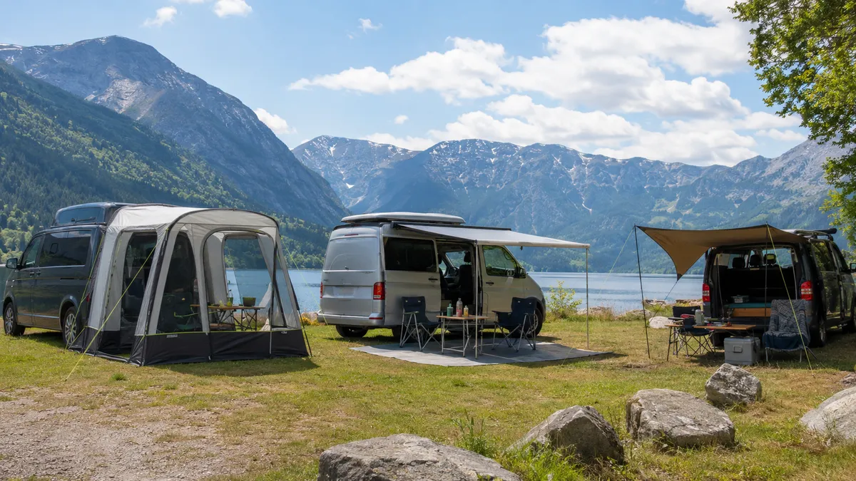 Small campervan with a deployed side awning, outdoor table and chair.