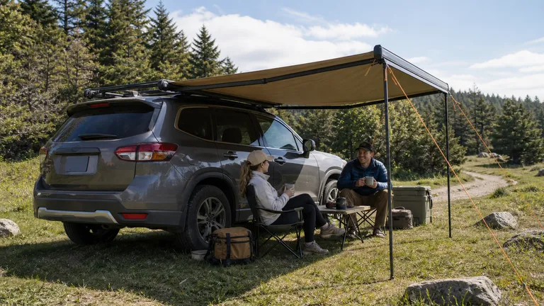 SUV parked in grass with a roof-rack side awning shelter set up at camp.